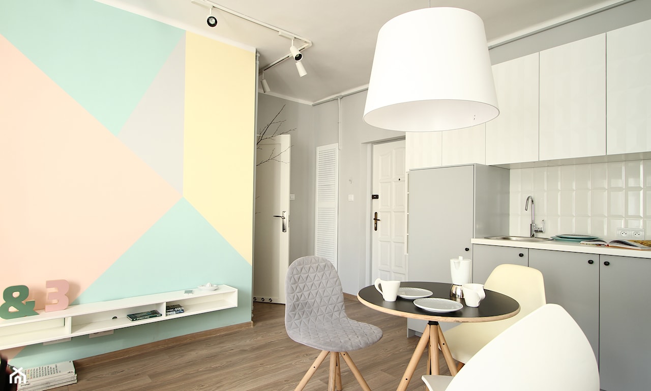 salon z kuchnią w stylu skandynawskim ze ścianą pomalowaną w geometryczne pastelowe wzory