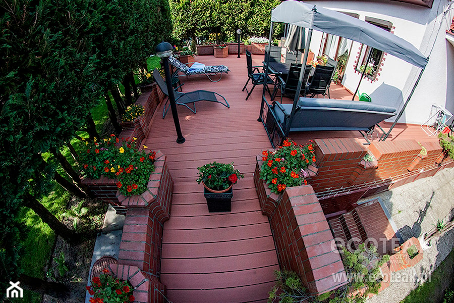 Tarasy - Duży z podłogą z desek z meblami ogrodowymi z donicami na kwiaty taras z tyłu domu - zdjęcie od EkoTeak