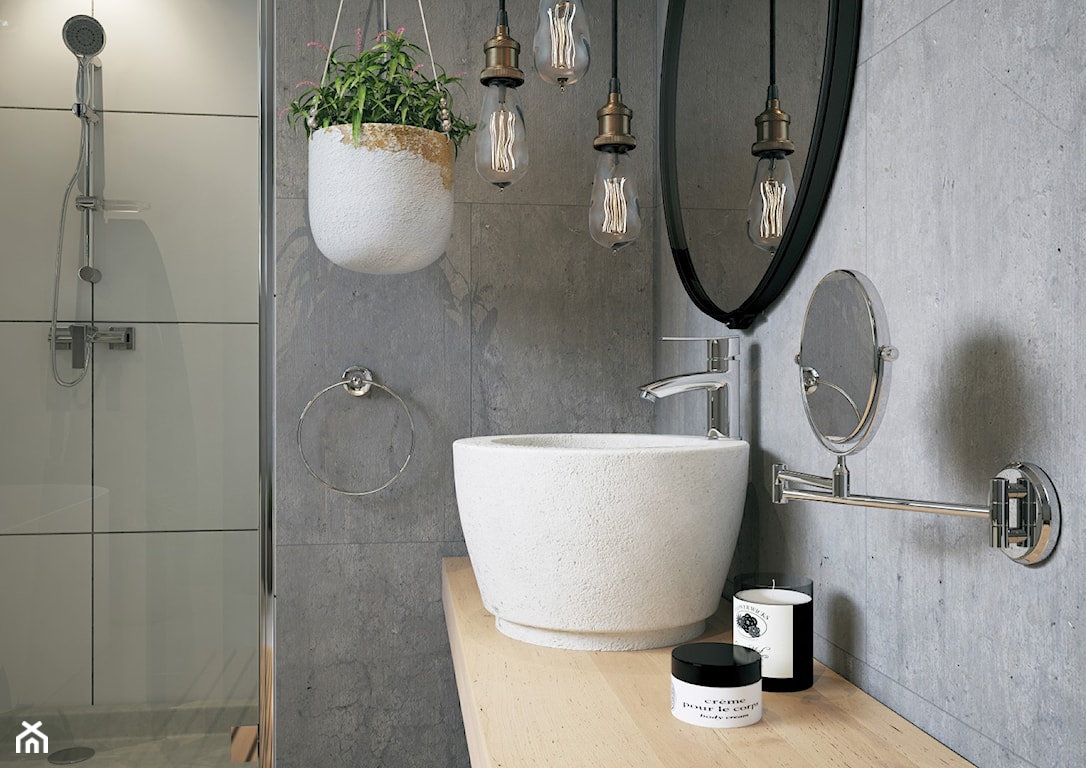 beton na ścianie, doniczka wisząca, umywalka nablatowa, okrągłe lustro, zestaw prysznicowy