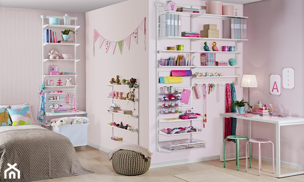 różowe ściany, dziecięce zabawki ustawione na półkach, białe biurko, okrągła pufa