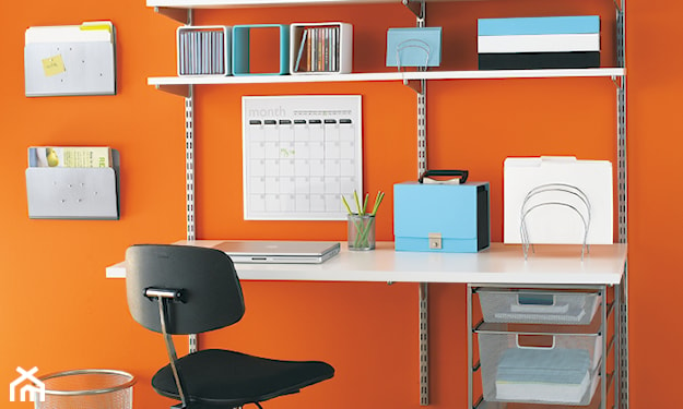 pomarańczowa ściana, czarny fotel biurowy, metalowe kosze