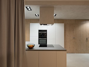 Biała minimalistyczna kuchnia - Średnia otwarta z kamiennym blatem z zabudowaną lodówką kuchnia w kształcie litery l z wyspą lub półwyspem z oknem, styl minimalistyczny - zdjęcie od Zirador - Meble tworzone z pasją