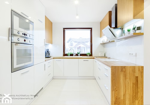 Beton, drewno i biel - Duża otwarta zamknięta biała z zabudowaną lodówką z nablatowym zlewozmywakiem kuchnia w kształcie litery u, styl nowoczesny - zdjęcie od IN projektowanie wnętrz