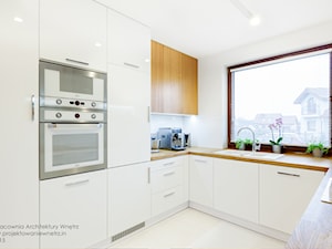 Beton, drewno i biel - Duża otwarta biała z zabudowaną lodówką z nablatowym zlewozmywakiem kuchnia w kształcie litery u z oknem, styl nowoczesny - zdjęcie od IN projektowanie wnętrz
