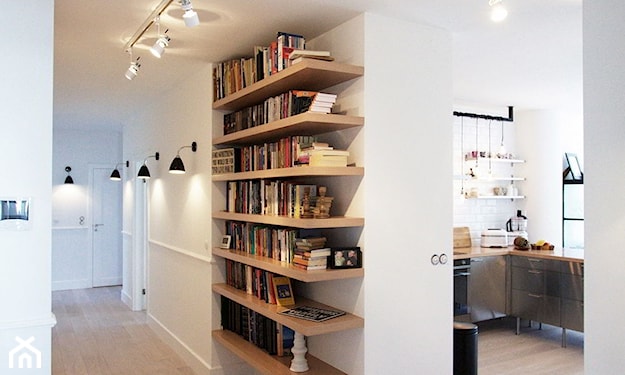 biały korytarz, drewniane półki na książki, długi i wąski korytarz