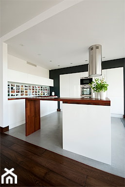 galeria zdjęć w przestrzeni między szafkami w kuchni, białe meble kuchenne, drewniana wyspa kuchenna