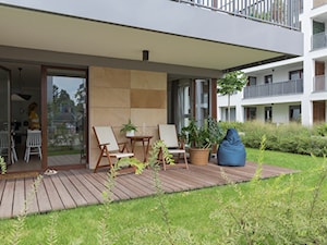 Apartament M&P - Mały z podłogą z desek z meblami ogrodowymi z donicami na kwiaty taras z tyłu domu - zdjęcie od Kraupe Studio