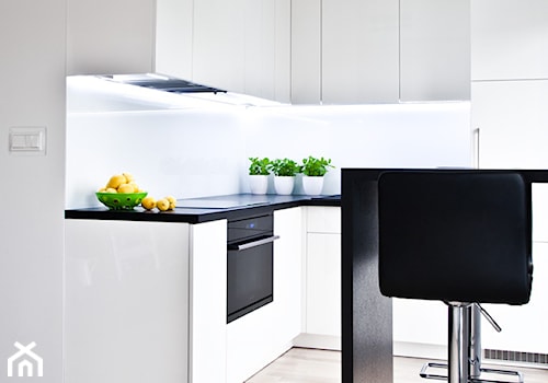 czarno - biała kawalerka - Mała średnia otwarta biała kuchnia w kształcie litery l, styl minimalistyczny - zdjęcie od nomad studio
