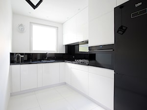 Biało-czarna kuchnia - Średnia zamknięta biała z zabudowaną lodówką z nablatowym zlewozmywakiem kuchnia w kształcie litery l z oknem, styl nowoczesny - zdjęcie od FORMA-MEBLE.PL