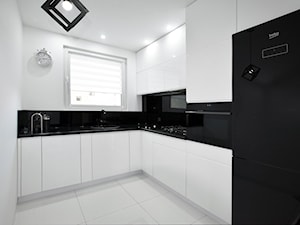 Biało-czarna kuchnia - Średnia zamknięta z salonem biała czarna z zabudowaną lodówką z lodówką wolnostojącą z nablatowym zlewozmywakiem kuchnia w kształcie litery l z oknem z kompozytem na ścianie nad blatem kuchennym, styl nowoczesny - zdjęcie od FORMA-MEBLE.PL