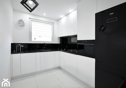 Biało-czarna kuchnia - Średnia zamknięta z salonem biała czarna z zabudowaną lodówką z lodówką wolnostojącą z nablatowym zlewozmywakiem kuchnia w kształcie litery l z oknem z kompozytem na ścianie nad blatem kuchennym, styl nowoczesny - zdjęcie od FORMA-MEBLE.PL