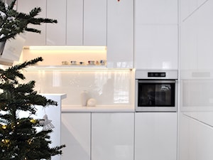 Kuchnia w bieli - Średnia otwarta z kamiennym blatem biała z zabudowaną lodówką kuchnia w kształcie litery l, styl nowoczesny - zdjęcie od FORMA-MEBLE.PL