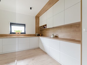 Projekt domu w okolicach Poznania ok. 120 m2 - Średnia zamknięta biała z zabudowaną lodówką kuchnia w kształcie litery l z oknem, styl nowoczesny - zdjęcie od Architektownia
