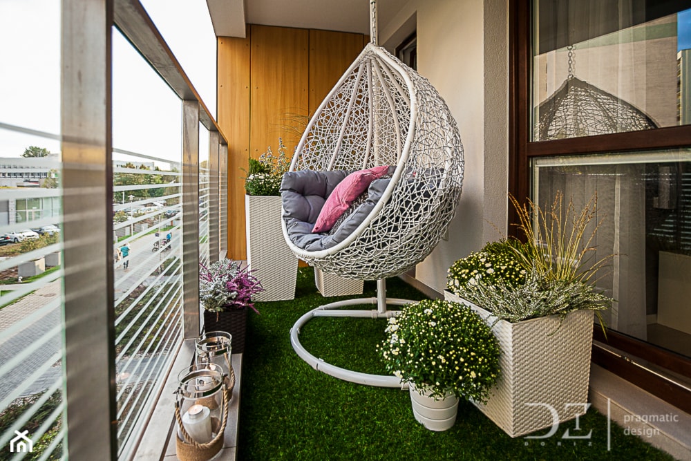 mały balkon w bloku ze sztuczną trawą