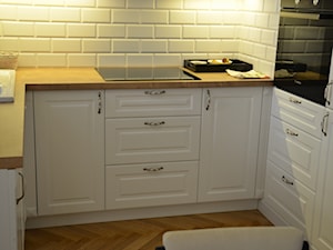 Mała otwarta biała z zabudowaną lodówką z nablatowym zlewozmywakiem kuchnia w kształcie litery u, styl prowansalski - zdjęcie od radi2005