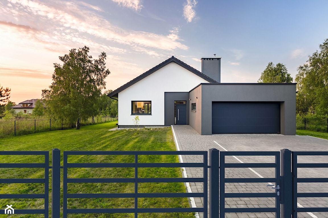 nowoczesny dom z metalową bramą i dużym trawnikiem