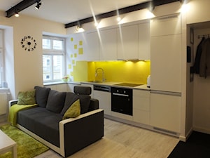 Mieszkanie Wrocław - Średnia otwarta z salonem żółta z zabudowaną lodówką z nablatowym zlewozmywakiem kuchnia w kształcie litery l jednorzędowa z oknem, styl nowoczesny - zdjęcie od MASTERHOME GROUP