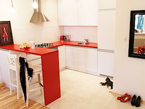 Salon z kuchnią w czerwieni. - Średnia otwarta biała z zabudowaną lodówką z nablatowym zlewozmywakiem kuchnia w kształcie litery u, styl nowoczesny - zdjęcie od Inside Story