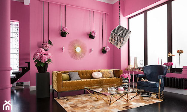 różowe ściany w salonie i złota sofa