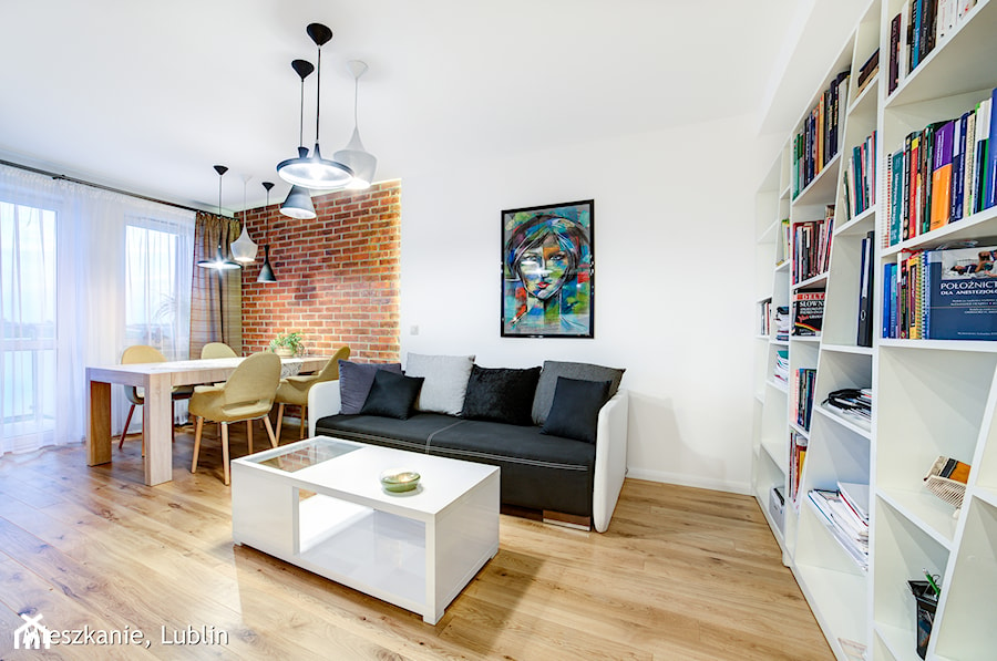 mieszkanie na Felinie Lublin - Duży biały salon z jadalnią z bibiloteczką, styl nowoczesny - zdjęcie od Auraprojekt