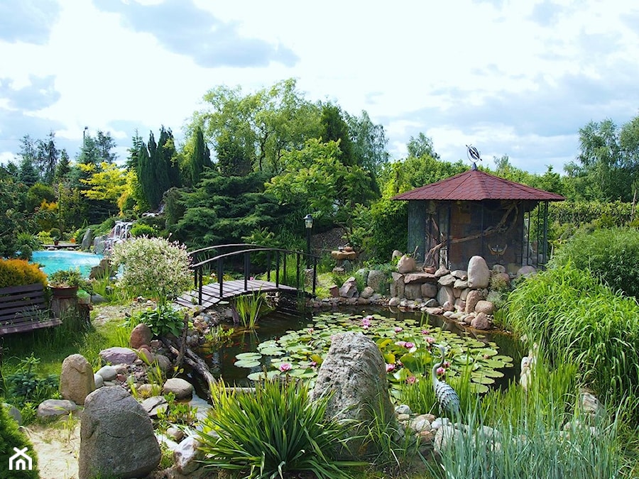 Śródziemnomorski ogród - Duży z kamienną nawierzchnią z lampami stojącymi ogród z oczkiem wodnym za domem - zdjęcie od Marcin Sumiła