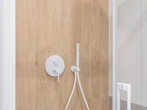 Łazienka z białą wanną, prysznicem i płytkami drewnopodobnymi - zdjęcie od Maxfliz Salony Wyposażenia Wnętrz