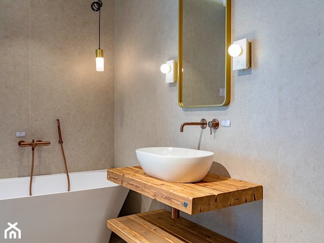 Łazienka z wanną i armaturą w szczotkowanej miedzi z drewnianym akcentem