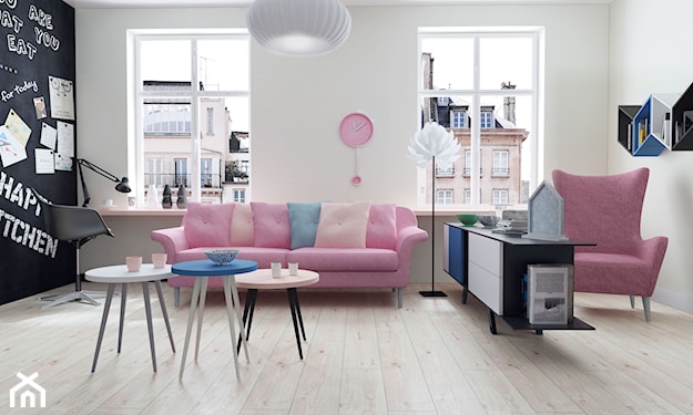 podłoga z jasnego drewna w salonie, różowa sofa, okrągłe stoliki na drewnianych nogach, różowy fotel