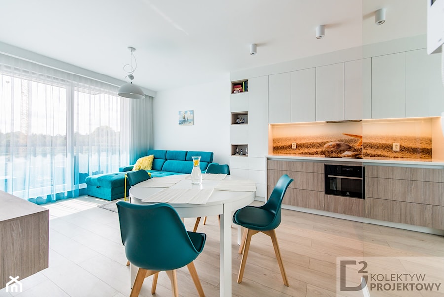 Turkusowe mieszkanie wakacyjne nad morzem - Duży biały salon z kuchnią z jadalnią, styl nowoczesny - zdjęcie od Kolektyw D2