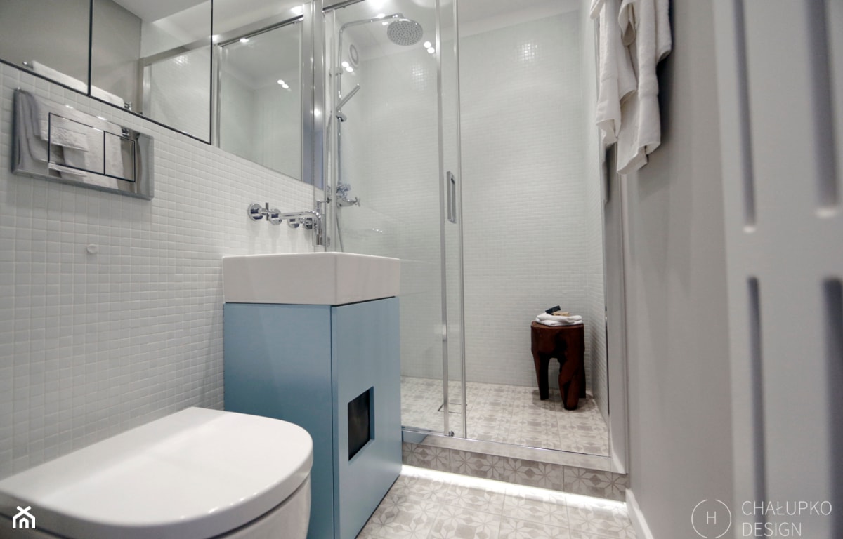 błękitna szafka łazienkowa, białe kafelki, kabina prysznicowa walk-in
