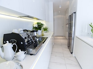 Apartament Biały - Średnia zamknięta z kamiennym blatem biała z zabudowaną lodówką z lodówką wolnostojącą kuchnia dwurzędowa, styl minimalistyczny - zdjęcie od Chałupko Design