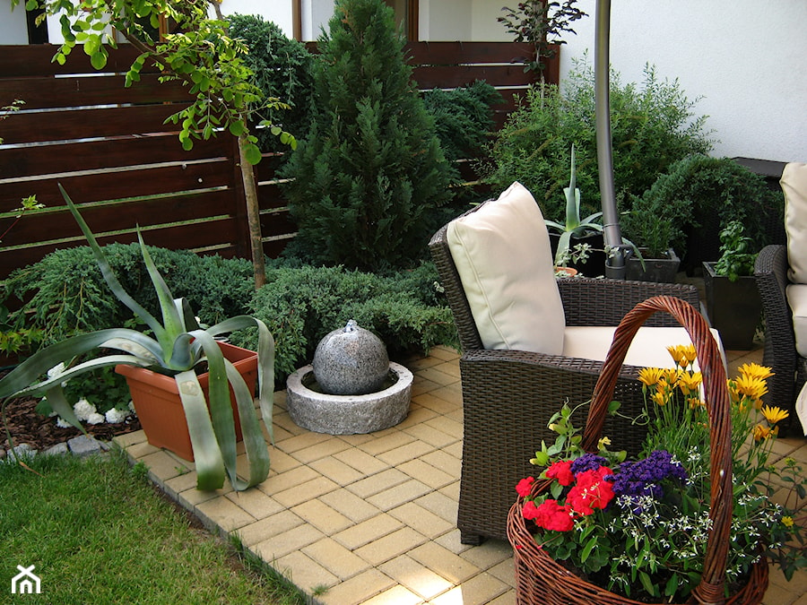Strefa wypoczynku - Średni z meblami ogrodowymi z donicami na kwiaty taras z tyłu domu - zdjęcie od metez