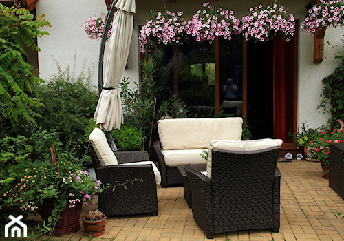 Strefa wypoczynku - Mały z meblami ogrodowymi z donicami na kwiaty taras z tyłu domu - zdjęcie od metez