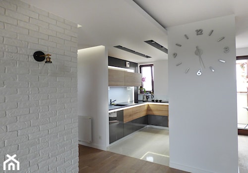 Apartament w ciemnych kolorach - Średnia otwarta z kamiennym blatem biała z zabudowaną lodówką z lodówką wolnostojącą z podblatowym zlewozmywakiem kuchnia w kształcie litery l z oknem - zdjęcie od evarte