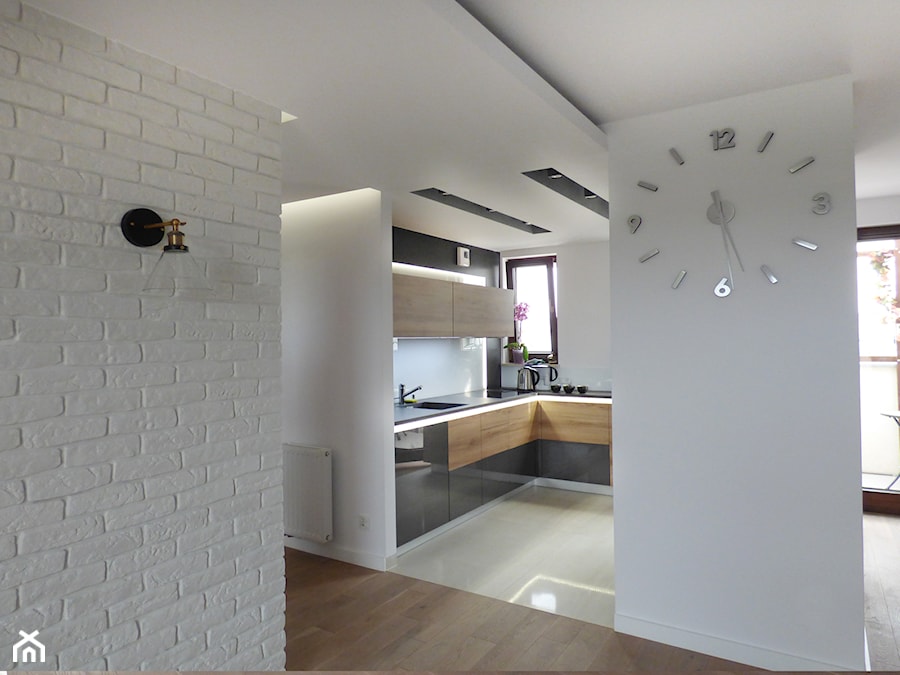 Apartament w ciemnych kolorach - Średnia otwarta z kamiennym blatem biała z zabudowaną lodówką z lodówką wolnostojącą z podblatowym zlewozmywakiem kuchnia w kształcie litery l z oknem - zdjęcie od evarte