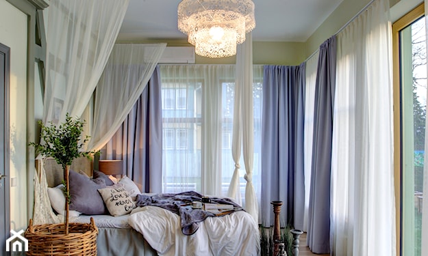 wiklinowa donica, łóżko z baldachimem, fioletowe zasłony, drewniana podłoga, brązowy dywan, biały żyrandol