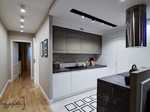 Mieszkanie z nutą klasyki - Średnia z salonem biała z zabudowaną lodówką z podblatowym zlewozmywakiem kuchnia w kształcie litery u z wyspą lub półwyspem, styl glamour - zdjęcie od Brygida Projektuje
