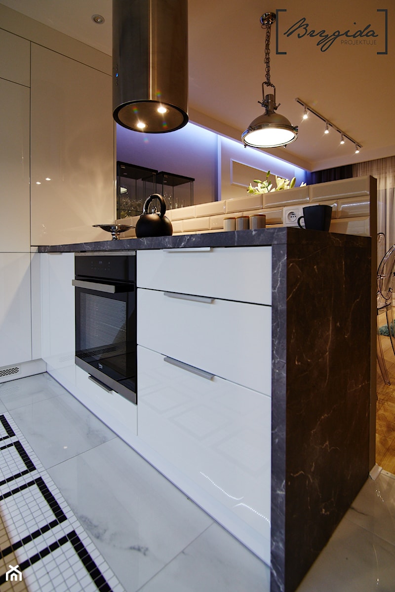 Mieszkanie z nutą klasyki - Mała otwarta z kamiennym blatem biała z zabudowaną lodówką kuchnia w kształcie litery l z wyspą lub półwyspem, styl glamour - zdjęcie od Brygida Projektuje