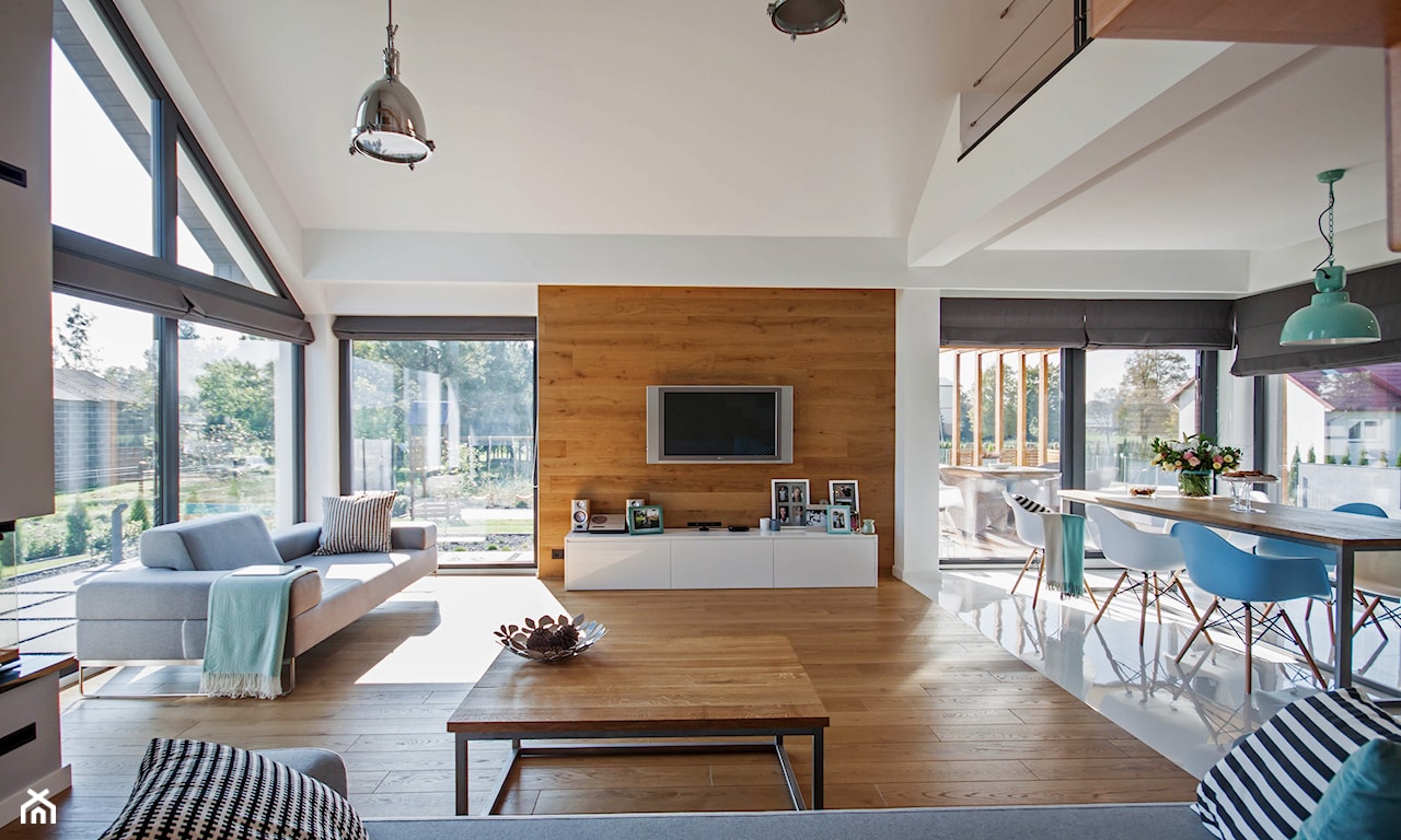 nowoczesny salon z drewnianymi panelami na ścianie, szara sofa na metalowych nogach, szare rolety wewnętrzne