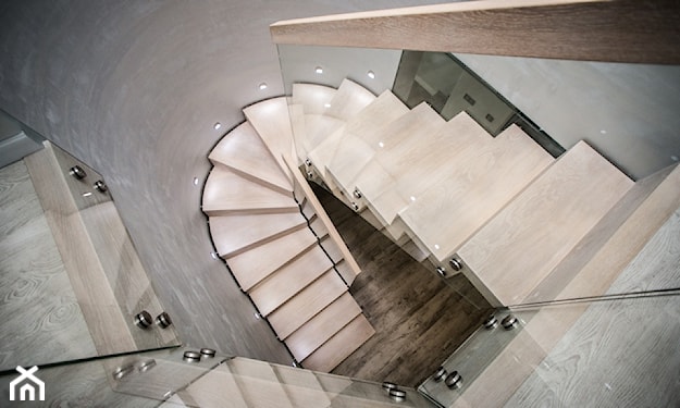 beżowe schody spiralne ze szklaną balustradą