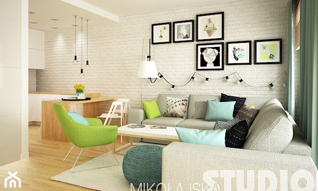 biała cegła, szara sofa, zielony fotel, biała lampa wisząca, beżowy dywan