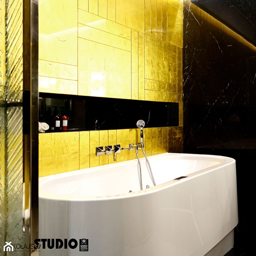 złota łazienka-widok części z elegancką wanną - zdjęcie od MIKOŁAJSKAstudio