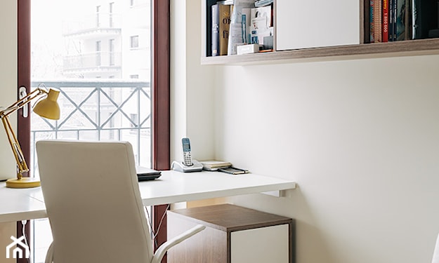 biały fotel biurowy, żółta lampka, kremowa ściana