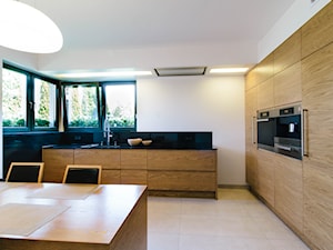 Dębowa, nowoczesna realizacja kuchenna - Duża otwarta biała czarna z zabudowaną lodówką z podblatowym zlewozmywakiem kuchnia w kształcie litery l z kompozytem na ścianie nad blatem kuchennym, styl nowoczesny - zdjęcie od Kuchnie Bogaccy
