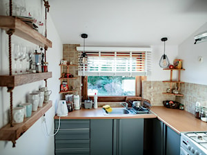 Sosnowy domek z kominkiem - Mała zamknięta biała szara z zabudowaną lodówką z lodówką wolnostojącą z nablatowym zlewozmywakiem kuchnia w kształcie litery l z oknem - zdjęcie od Homebook.pl