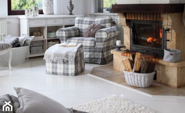 fotel w biało-szarą kratę, kominek, biała podłoga, kremowy dywan