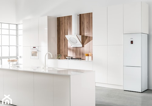 Kuchnia - Średnia otwarta z kamiennym blatem biała z zabudowaną lodówką z podblatowym zlewozmywakiem kuchnia dwurzędowa z oknem, styl minimalistyczny - zdjęcie od Amica
