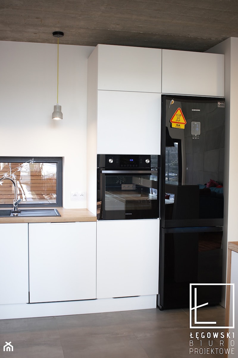 Realizacja domu jednorodzinnego w Jaworznie - Mała otwarta biała z zabudowaną lodówką z nablatowym zlewozmywakiem kuchnia jednorzędowa z oknem, styl nowoczesny - zdjęcie od Łęgowski Biuro Projektowe