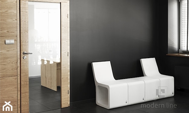 białe betonowe siedziska, grafitowa ściana, drzwi z lustrem