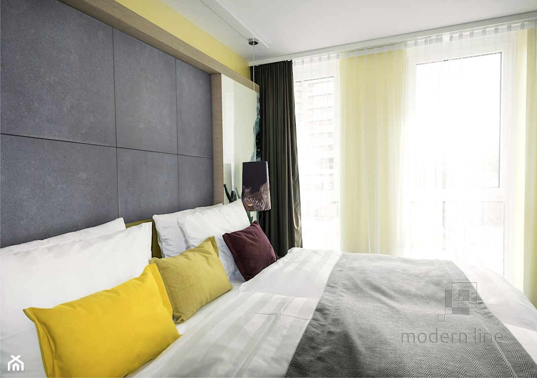 żółta poduszka, betonowe płytki w sypialni, szara narzuta, biała pościel